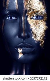 fashion portrait of a blue-skinned girl with gold make-up.Beauty face. Picture taken in the studio on a black background.