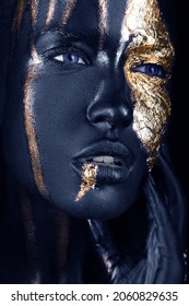 fashion portrait of a blue-skinned girl with gold make-up.Beauty face. Picture taken in the studio on a black background.