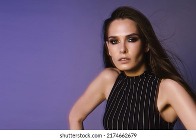 Fashion Portrait Of A Brunette With Long Hair And 90s Style Makeup Through A Crystal Filter, Overalls And A Red Leather Belt On A Purple Background