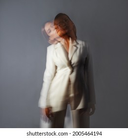 Fashion Portrait With The Effect Of Blurring In Motion At A Long Shutter Speed, Distortion Of The Model's Face. Alter Ego, Soul Movements, Concept. Young Stylish Woman In A White Jacket