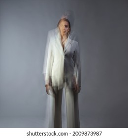 Fashion Portrait With The Effect Of Blurring In Motion At A Long Shutter Speed, Distortion Of The Model's Face. Alter Ego, Soul Movements, Concept. Young Stylish Woman In A White Jacket