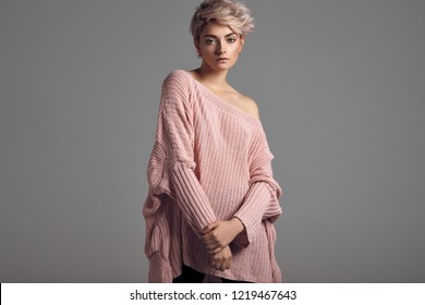 Fashion portrait of female model with blond short hair wear sweater 