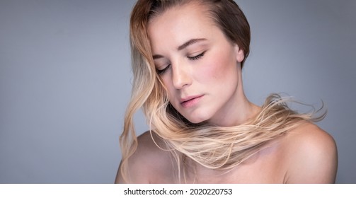 Fashion Portrait Of A Gentle Blond Woman With Closed Eyes Isolated On Gray Background. Genuine Beauty Of A Young Girl. Natural Beauty.