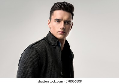 Fashion portrait of a handsome man with trendy hairstyle in a stylish jacket . 