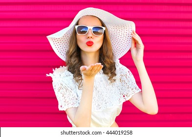 Fashion Portrait Pretty Woman In Summer Straw Hat Sends An Air Kiss Over Colorful Pink Background