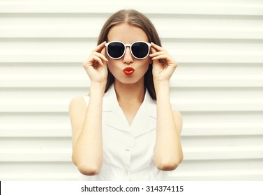 Fashion portrait of pretty young woman in white sunglasses 
