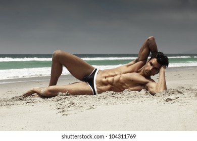 Fashion Portrait Of A Sensual Gorgeous Male Model In Swimwear Posing On Beach