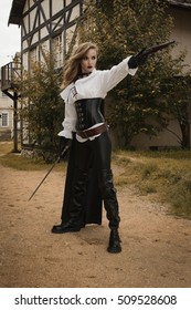 Fashion portrait of sexy woman in pirate style with old handgun