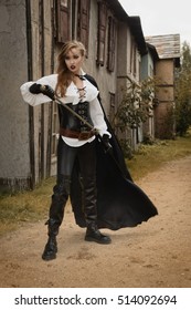 Fashion portrait of sexy woman in pirate style holding sword