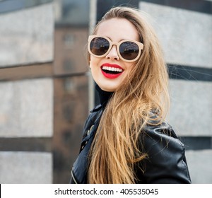 Fashion Portrait Stylish Pretty Woman In Sunglasses Outdoor. Young Smiling Woman Wearing A Rock Black Style Having Fun In City. Street Fashion. Red Lipstick.