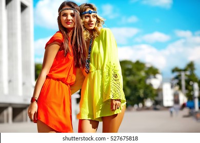 Fashion portrait of two young hippie women models in summer sunny day in bright colorful hipster clothes