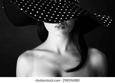 Fashion Portrait Of A Woman With Lock Hair And  Black And White Dots Hat And Pout Lips