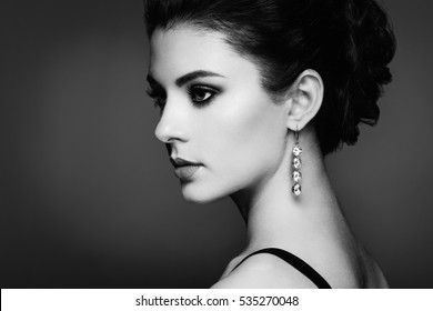 Fashion portrait of young beautiful woman with jewelry. Brunette girl. Perfect make-up.  Beauty style woman with diamond accessories. Black and White