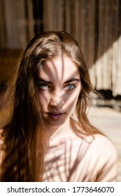 Fashion Portrait Of Young Blondish Woman With Shadows On Her Face. Light And Shadow. Interesting Portrait Of Young Girl's Face Covered With Unusual Shadow.