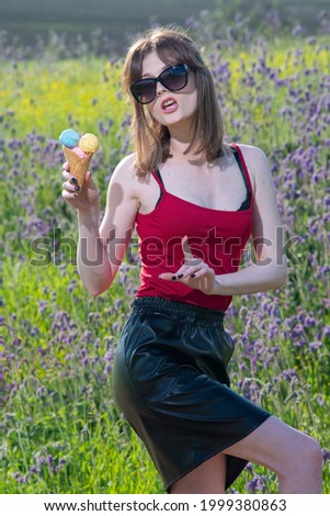 fashion portrait of a young happy beautiful girl with ice cream in her hands, in a field on a floral background.