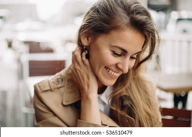 Fashion Portrait Of Young Woman Sitting Street Cafe. Street Fashion,smiling,happy,blonde,camel Color Of Coat, Enjoying Warm, Harmony. Authentic. Closeup Portrait.