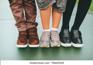 Fashion Shoes On Kids. Three Pairs Of Children's Feet Wearing Comfortable And Fashion Trainers. Back To School Concept