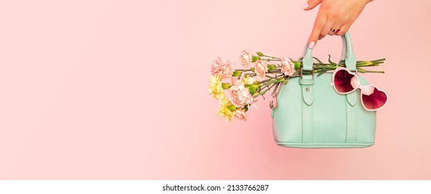 Fashion spring accessories for woman - banner. Small mint green handbag (purse), heart shaped sunglasses and flowers on pastel pink background. Free copy (text) space. - Powered by Shutterstock