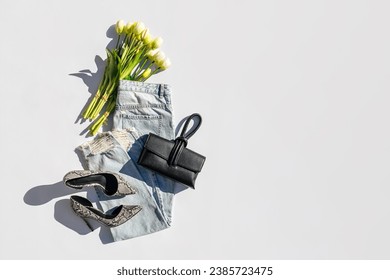 Fashion spring outfit. Blue jeans with bouquet of tulips flowers, heeled shoes and handbag. Women's stylish and elegant clothes with accessory and jewelry. Fashionable look. Flat lay, top view. - Powered by Shutterstock