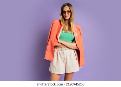 Fashion Studio Photo Of Elegant Blond Woman In Trendy Pink Jacket Posing On Purple Background. Spring.