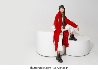 Fashion Studio Photo Of Stylish European Brunette Woman In Red Coat And Black Hat Posing On White Background.  Trendy Winter Accsesorises.