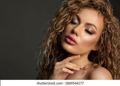 Fashion studio portrait of adorable blonde woman with lush hair and naked shoulders. Empty space