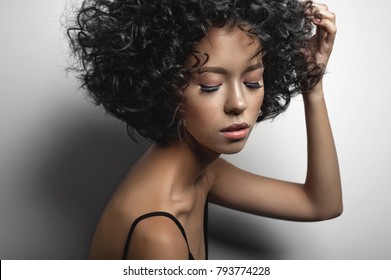 Fashion Studio Portrait Of Beautiful Woman In Black Dress With Afro Curls Hairstyle. Fashion And Beauty