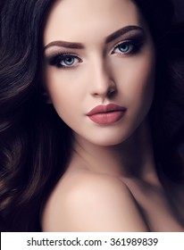 Fashion Studio Portrait Of Beautiful Young Woman With Long Dark Hair And Blue Eyes With Bright Makeup