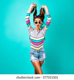 Fashion studio portrait of glamour sportive girl, smart casual outfit, cute emotions, stylish hipster clothes sunglasses and backpack, spring pastel colors. mini hipster denim shorts crazy emotions.
