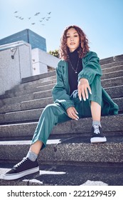 Fashion, style and city with a model black woman sitting on stairs outside during a summer day. Clothes, urban and lifestyle with a trendy, edgy or stylish young female posing outdoor in a town