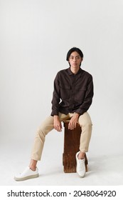 Fashion And Style , Young Man Wearing Brown Shirt With Khaki Pants Sitting Chair In Studio
