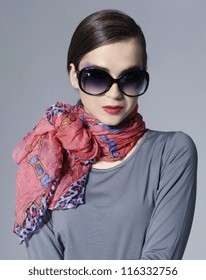 Fashion stylish girl in scarf on gray background