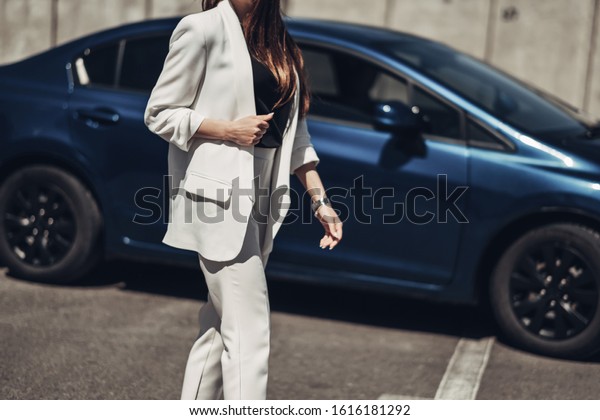 Fashion Stylish Girl in White Suit Posing Near the\
Blue Car