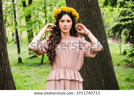 Fashion Summer Model Girl with Long Blowing Hair. Summer Beautiful Woman with Healthy and Beauty Brown Hair with Green Grass on Sunny Background,
