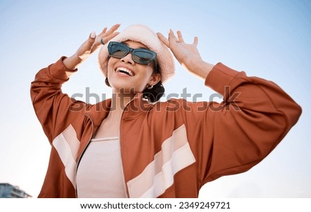 Fashion, sunglasses and smile with a trendy woman outdoor on a blue sky for freedom, energy or style. Portrait, summer and clothes with a happy young model in an urban outfit while on vacation
