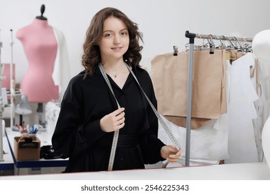 Fashion tailor woman working on clothes in tailoring atelier. Young female designer smile in studio on work place. - Powered by Shutterstock