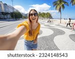 Fashion tourist woman takes selfie photo on Copacabana beach promenade, Rio de Janeiro, Brazil