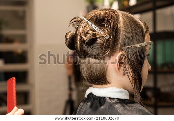 Fashion Trendy Hairdo. Bob\
Haircut Technology Classic Version. Little Girl with Short Bob\
Hair. Close Up Side View. Hairtician Cuts her Hair. Modern Children\
Hairstyle