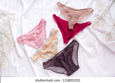 Fashion trendy lace lingerie. Different panties on white bed background. Beautiful sets to choose from. Colorful women's underwear, flatlay. Female wardrobe, shopping concept.