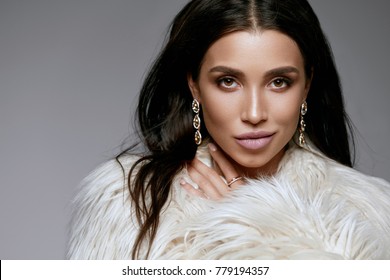 Fashion. Woman With Beauty Makeup In Fur With Jewelry. Portrait Of Young Sexy Model In Luxury Beige Faux Fur Jacket Wearing Long Gold Diamond Earrings. Women Winter Look. High Quality Image.