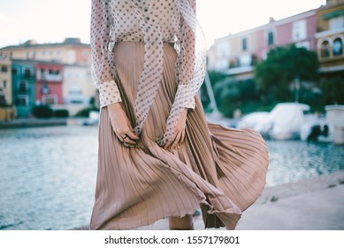 fashion woman in beige dress standing in yacht bay in windy day