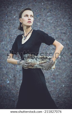 Similar – beautiful brunette short hair girl leaning against  gray rock wall outdoors, wearing black clothes