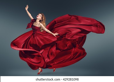 Fashion Woman Dancing In Fluttering Red Long Dress