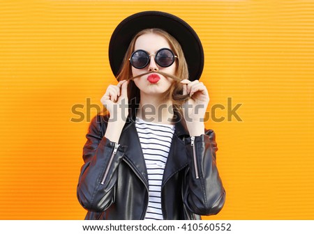 Fashion woman having fun shows mustache hair over orange background