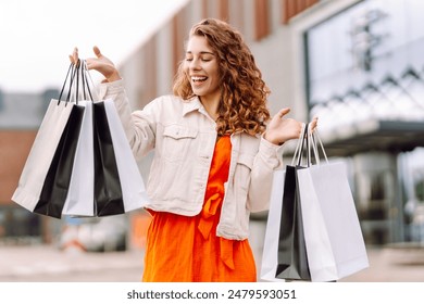 Fashion woman with shopping bags walking around the city after shopping. Consumerism, sale, purchases, shopping, lifestyle concept. - Powered by Shutterstock