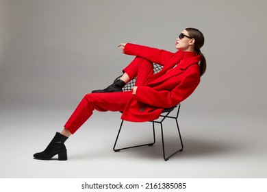 Fashion woman in trendy red outfit. Total red look, sunglasses, red coat, poloneck, pants