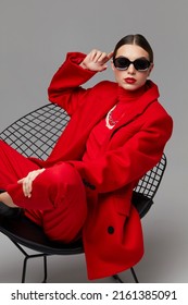 Fashion woman in trendy red outfit. Total red look, sunglasses, red coat, poloneck, pants