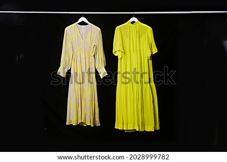 Fashion woman two dress on hanger on black background

