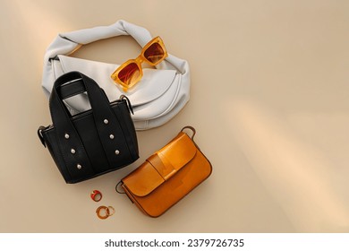 Fashion women's handbags on beige background. Stylish accessories. Leather Bags. Trendy outfit.  Flat lay, top view.  Fashion concept. - Shutterstock ID 2379726735