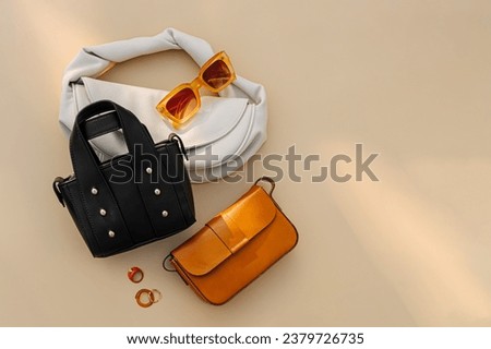 Fashion women's handbags on beige background. Stylish accessories. Leather Bags. Trendy outfit.  Flat lay, top view.  Fashion concept.